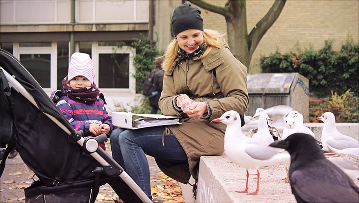 Eine Mutter und ein Kind füttern Möwen