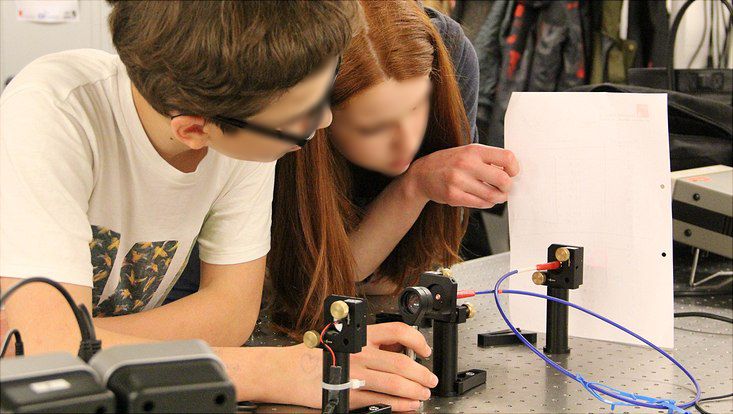 2 Jugendliche experimentieren mit Glasfaser