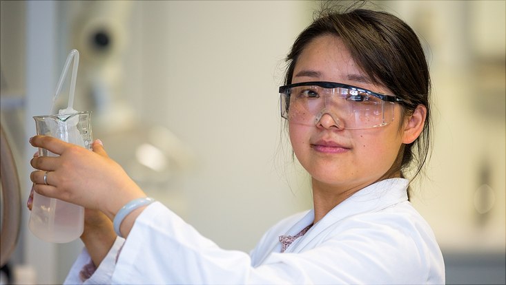 Laborantin arbeitet an einem Abzug